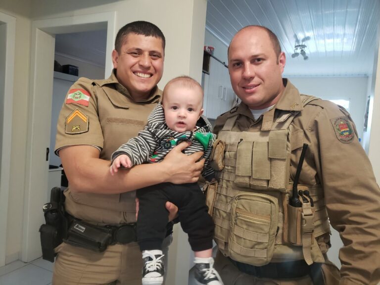 Bebê salvo por policiais que faziam patrulhamento recebe visita dos militares e ganha presentes